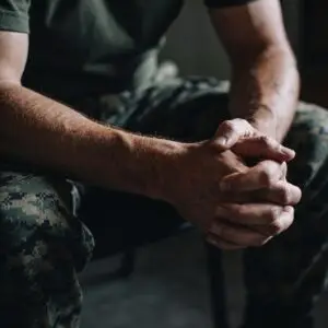 Military man sitting with his hands folded