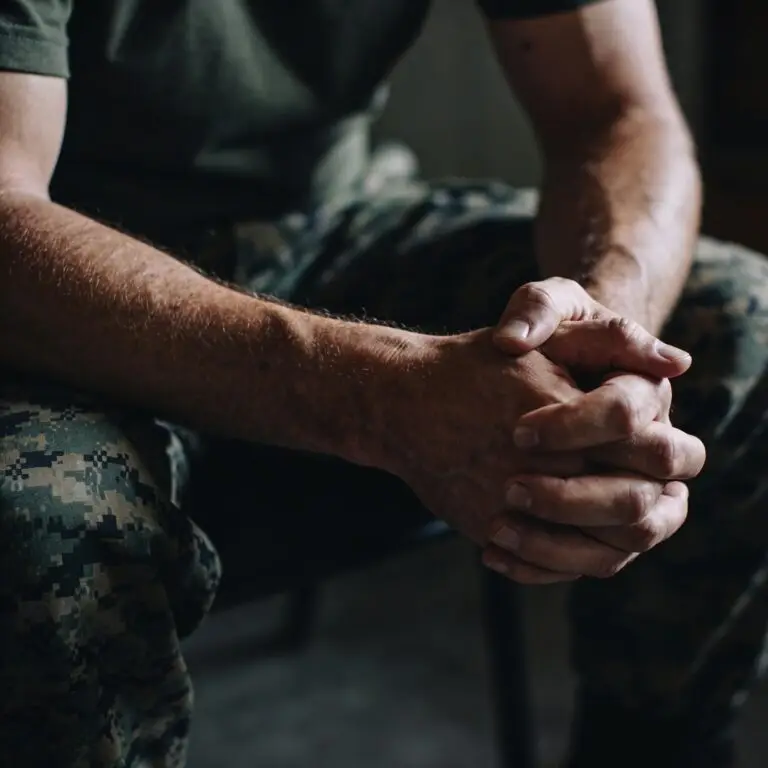 Military man sitting with his hands folded