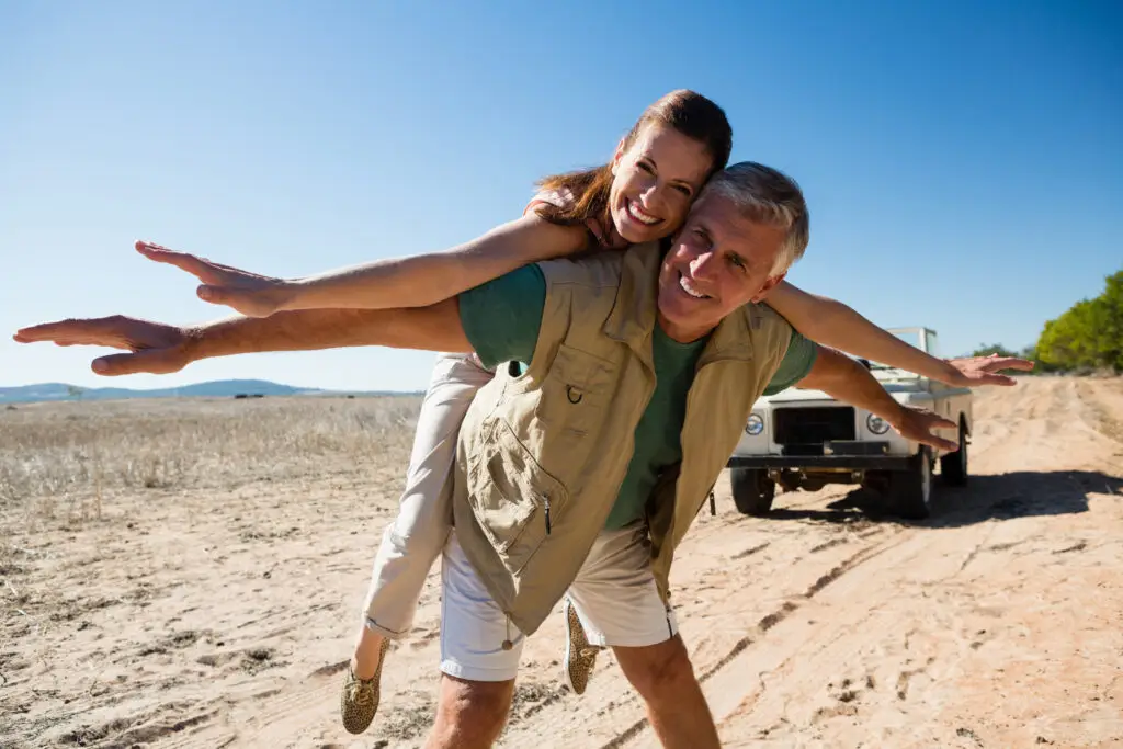 Man with woman on his back as they stretch out their arms in the desert of las vegas happily because they found great psychiatric care at mindwell