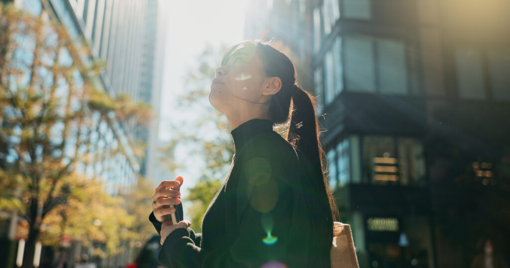 Woman standing in sunlight looking up because she has ADHD near las vegas and she is going to go to mindwell