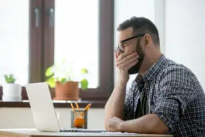 person sitting at desk looking tired in las vegas potentially with cerebral folate deficiency