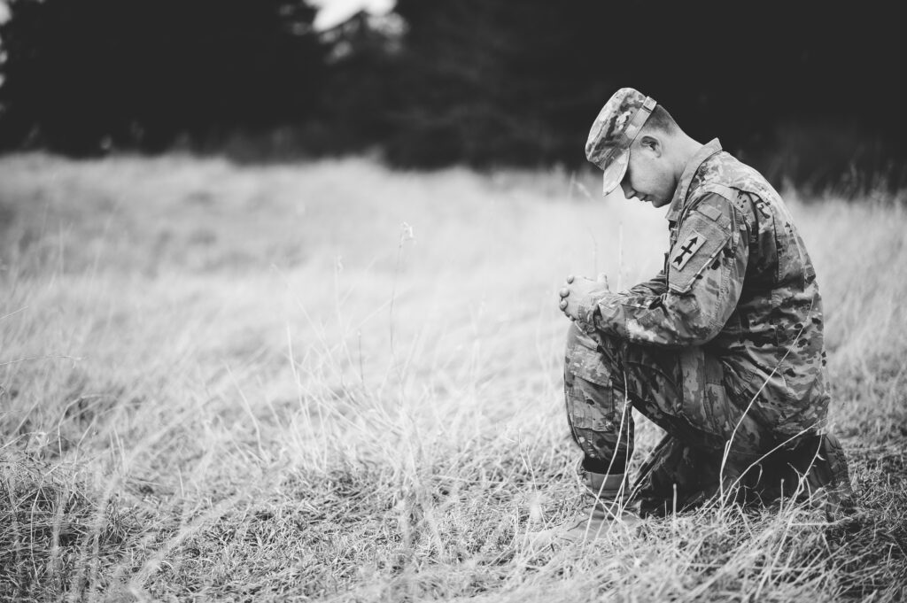 veteran kneeling in a grass field dealing with combat ptsd in las vegas