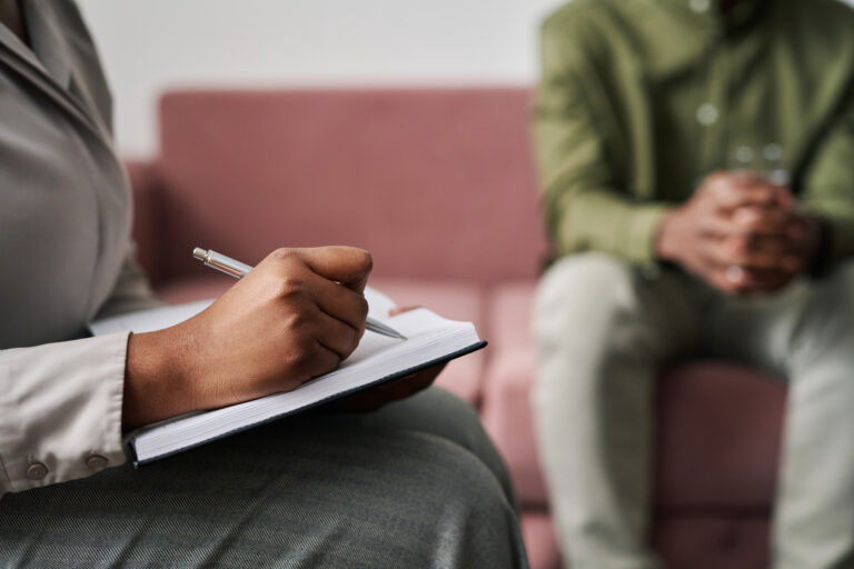 psychiatrist or pmhnp writing on clipboard with patient in las vegas
