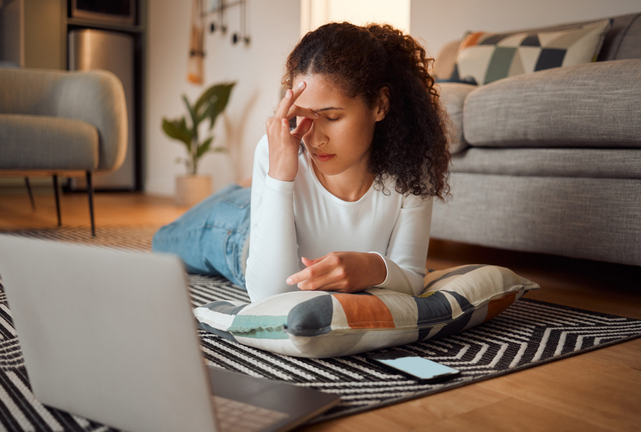 woman laying on the floor with hand in palm at laptop dealing with moral injury in las vegas