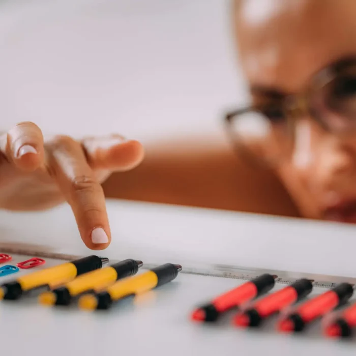Woman with OCD – Obsessive compulsive disorder concept. Placing paperclips in a straight line.